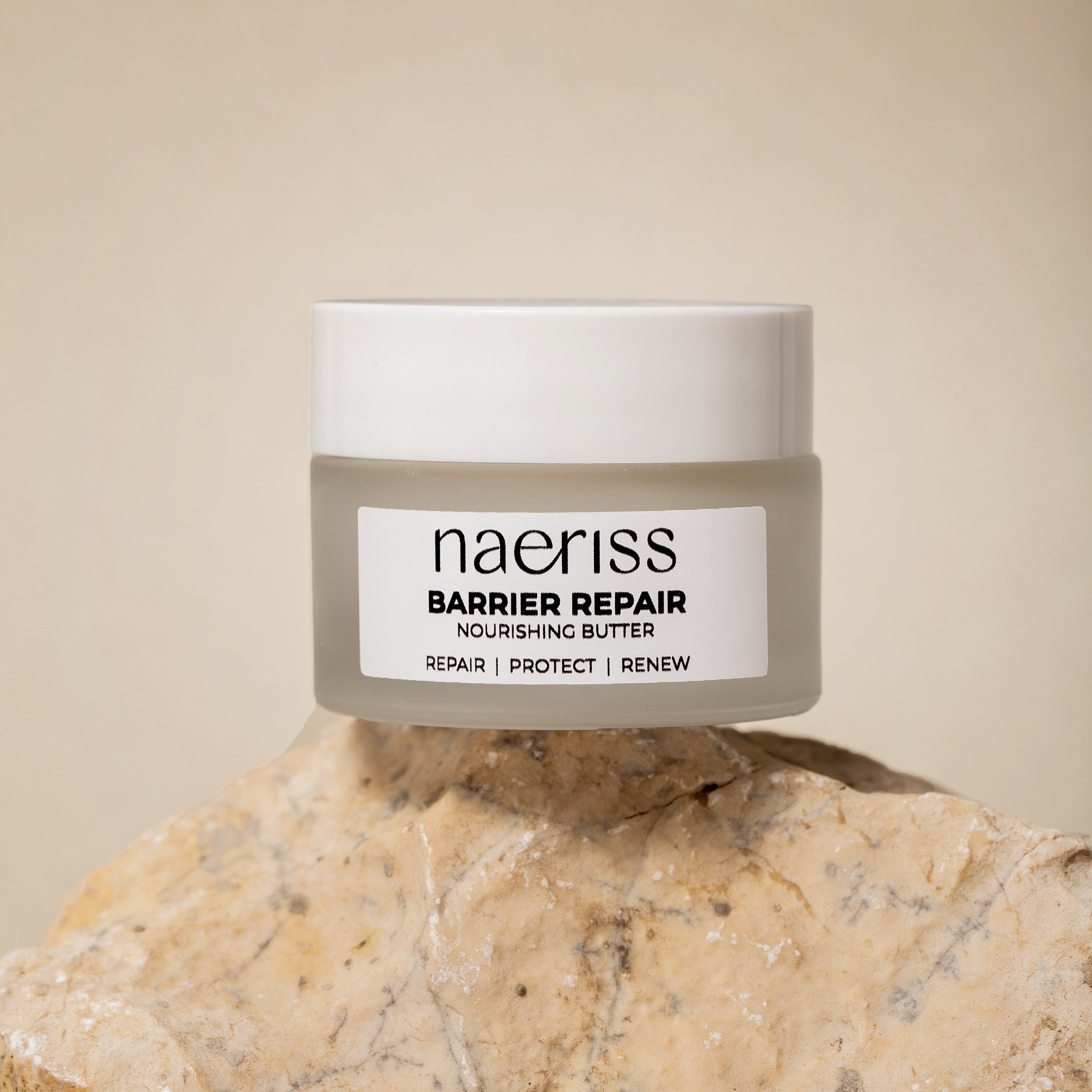 Jar of naeriss Barrier Repair Nourishing Butter on a stone surface with a beige background